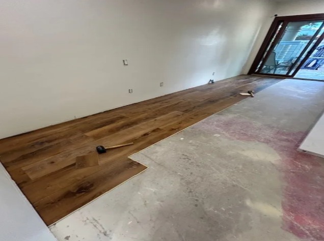 Flooring installation project with new hardwood-style flooring